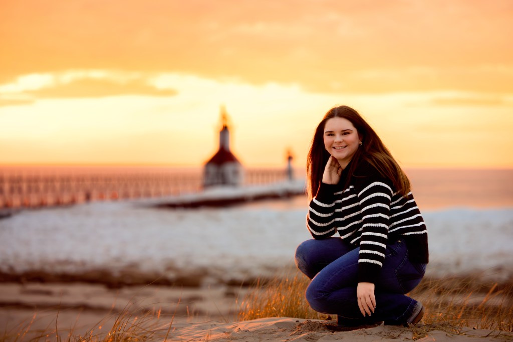 Senior posing in front of Michigan lighthouse in St. Joseph michigan
