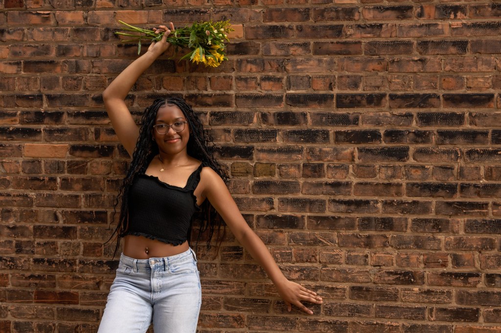 Senior girl downtown st. joseph michigan posing for senior pictures with flowers