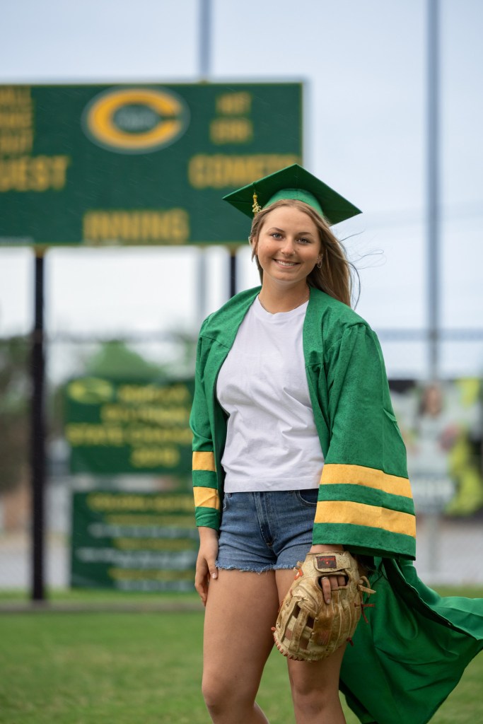 Coloma softball senior standing on home field during Class of 2026 cap and gown session