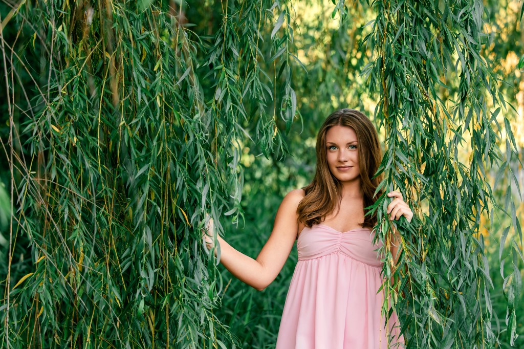 St. Joseph High School senior Emma beneath a graceful willow tree during her summer senior portrait session in Southwest Michigan.
