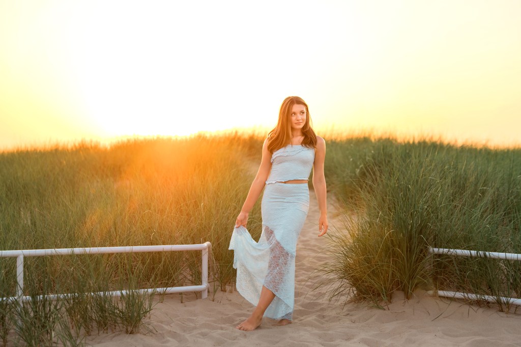 Horizontal senior portrait of Emma enjoying golden hour at Jean Klock Beach during her Southwest Michigan senior pictures.