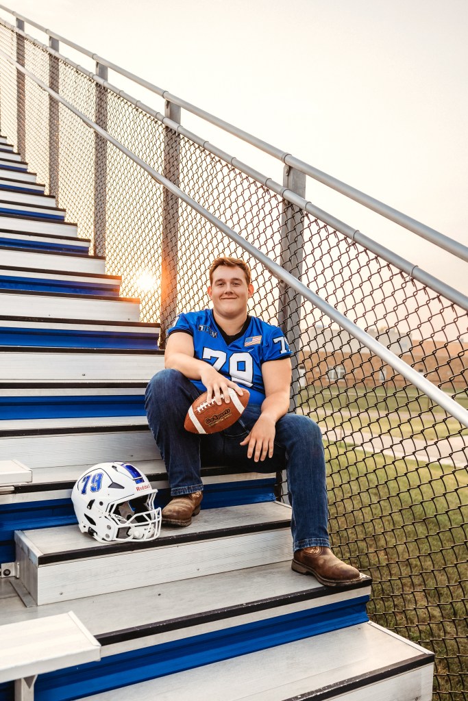 Lawton High School Class of 2027 senior sitting on football stadium bleachers during a Southwest Michigan senior portrait session.