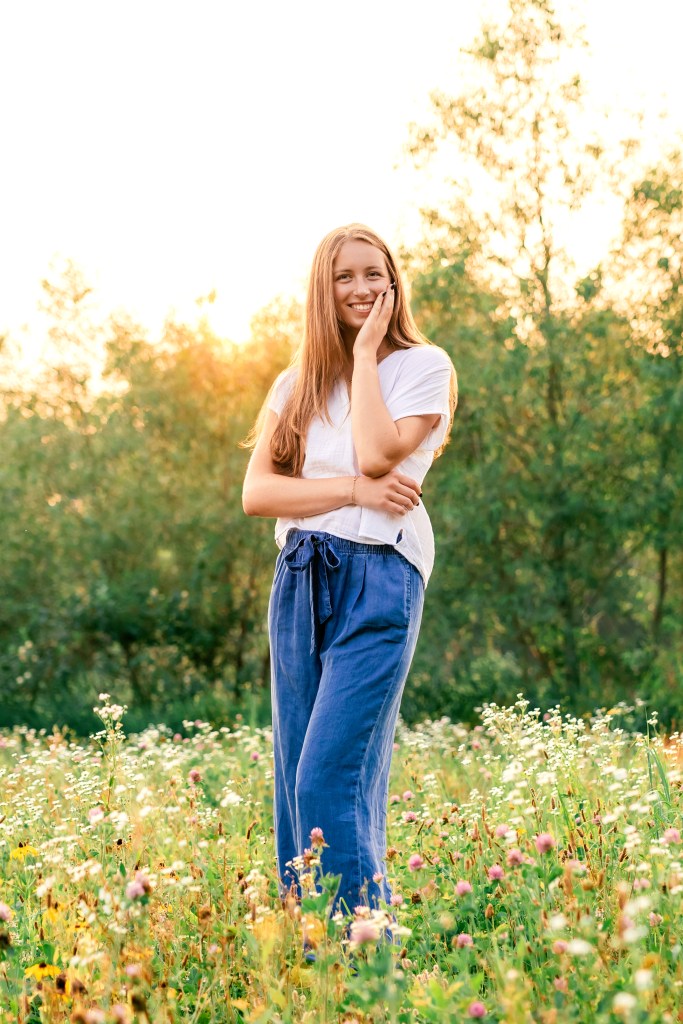 High school female senior posing in wildflower field in Benton Harbor Michigan